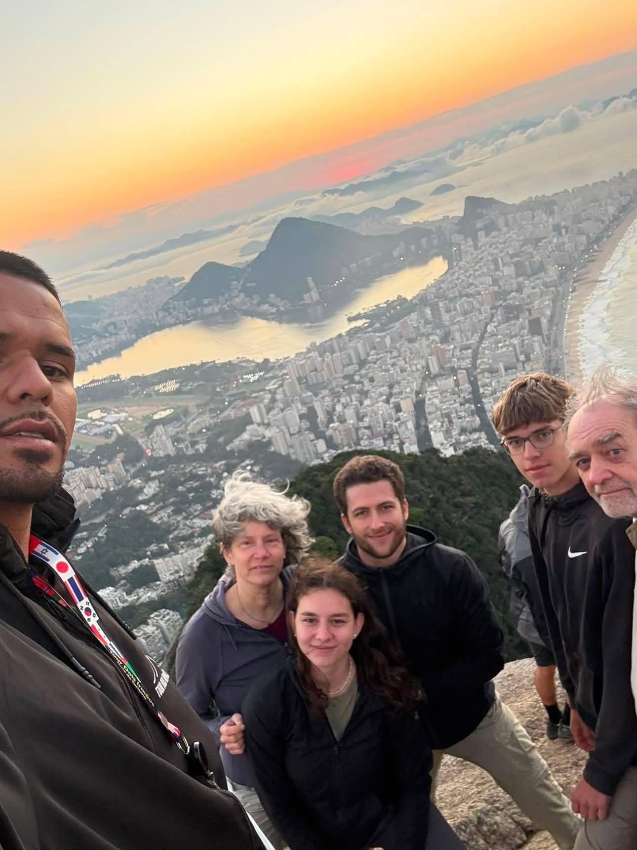 Grupo de turistas com o guia no nascer do sol, com a Lagoa e a orla ao fundo