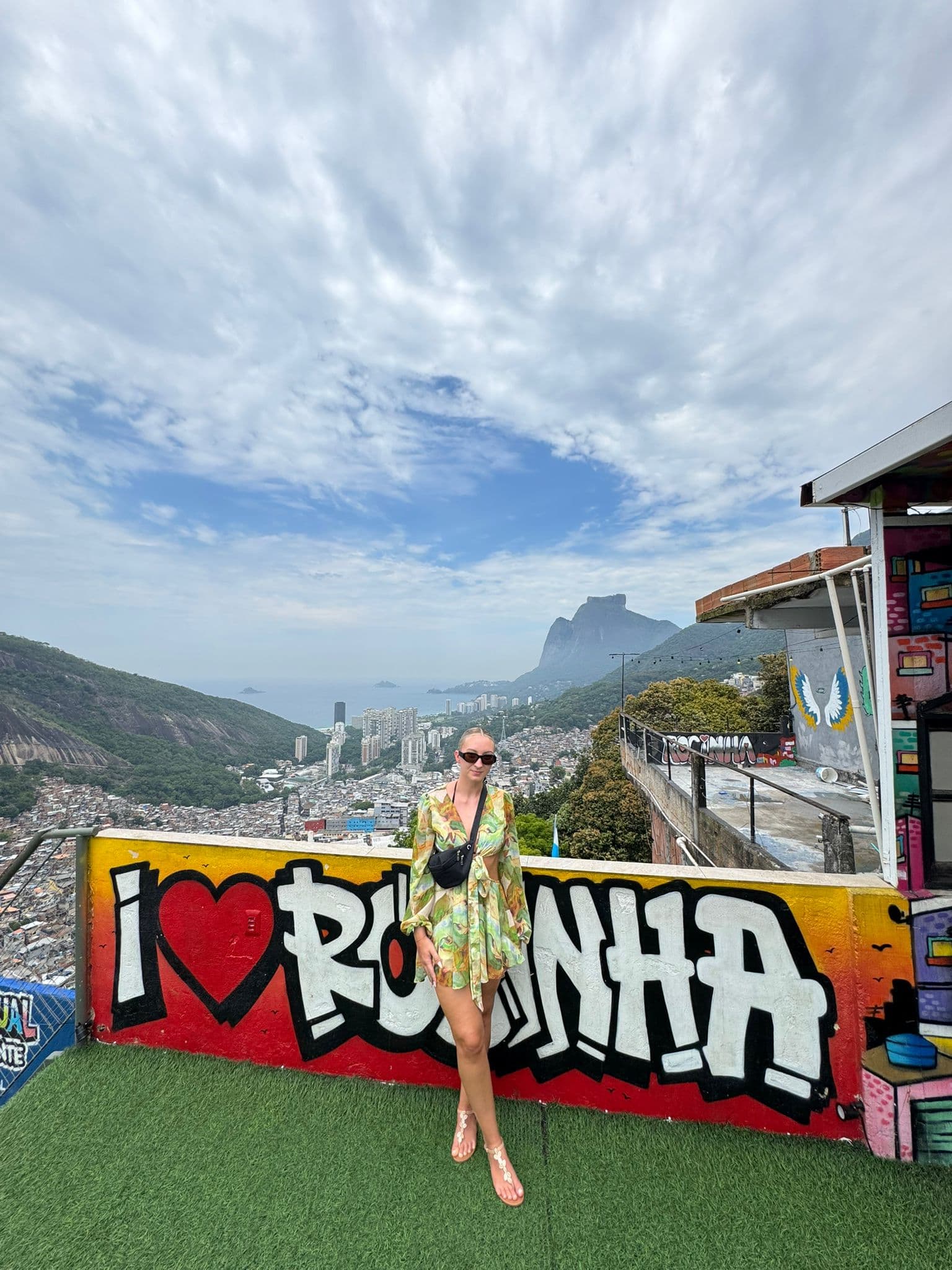Turista em frente ao painel de arte urbana 'I Love Rocinha'