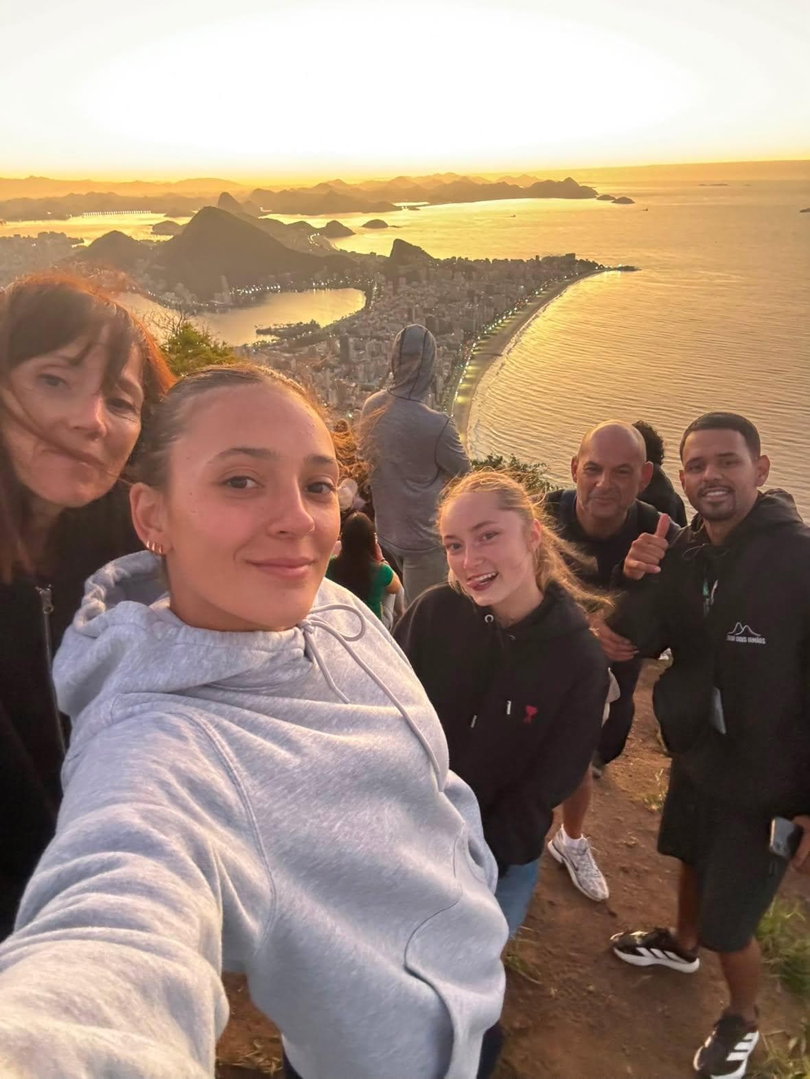 Turistas reunidos no topo do morro durante o nascer do sol