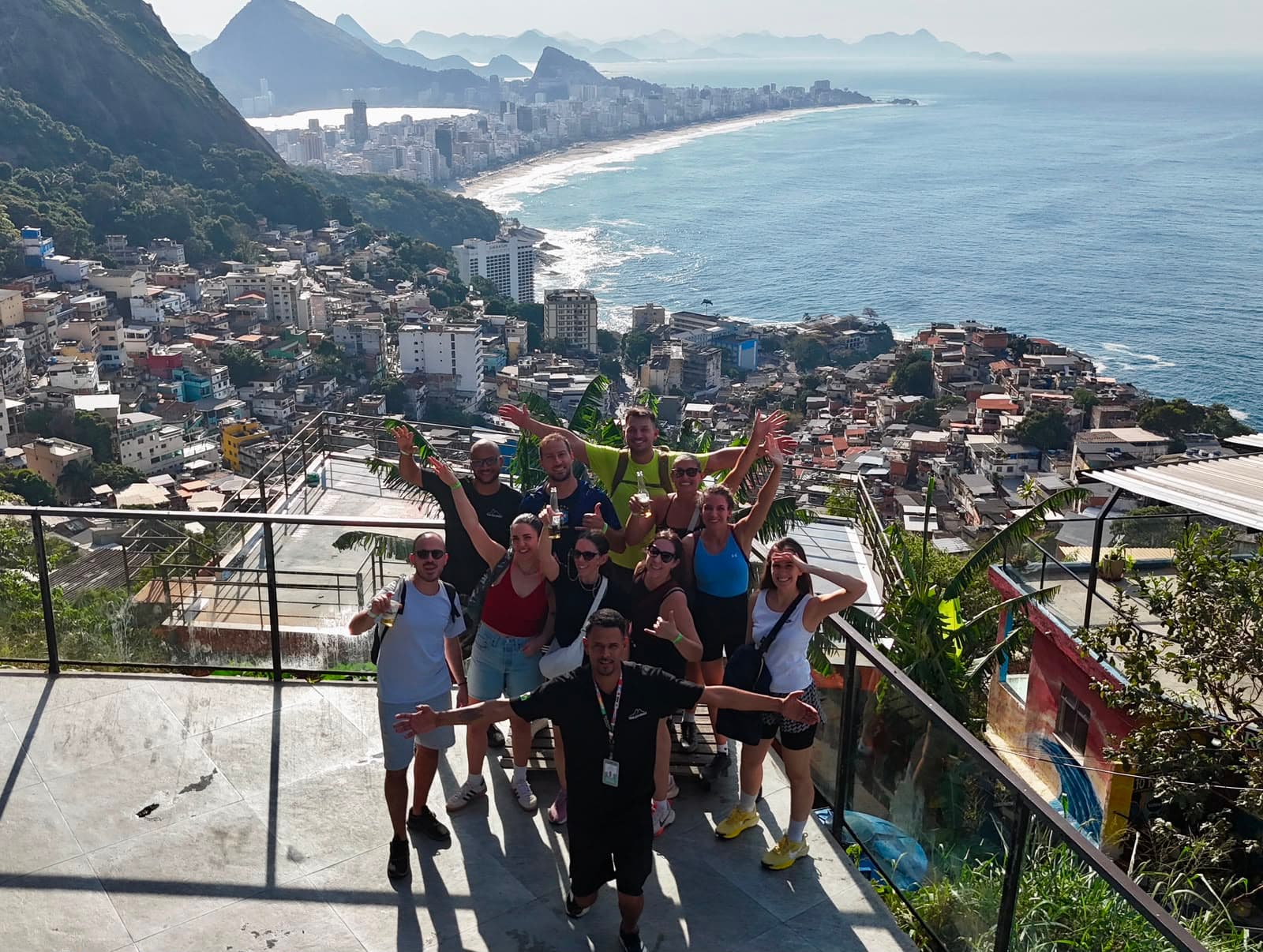Grupo comemorando em laje do Vidigal com vista para a praia
